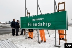 Macedonian workers change the the sign of the Alexander the Great highway going to Greece to Friendship highway on March 2.