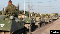 Russian military personnel sit atop armored vehicles outside Kamensk-Shakhtinsky in Russia's Rostov region on August 15.