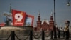 Žena stoji na ulici ukrašenoj plakatima povodom Dana pobjede u centru Moskve, 6. maja 2026.