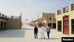 Residents walk at a new state-run development project in the old quarter of Shi'ite town Awamiya, Saudi Arabia January 8, 2019. REUTERS/Stephen Kalin