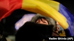 A woman waves a Romanian flag during a protest in Bucharest.