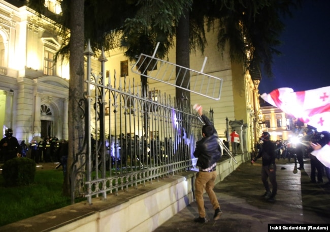 Një protestues përpiqet të hyjë me forcë në pallatin presidencial në Tbilisi, Gjeorgji, 4 tetor 2025.