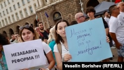  Протестиращи с плакати с надписи „ Незабавна промяна “ и „ Мечтая да церя, без да мизерувам “ 