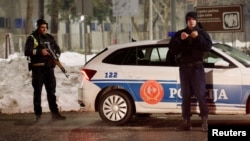 Police stand at a checkpoint near where a gunman opened fire at a restaurant and killed several people in the Montenegrin city of Cetinje on January 1. 