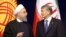 Iranian President Hassan Rohani (left) talks to Kyrgyz President Almazbek Atambaev during their meeting in Bishkek on December 23.