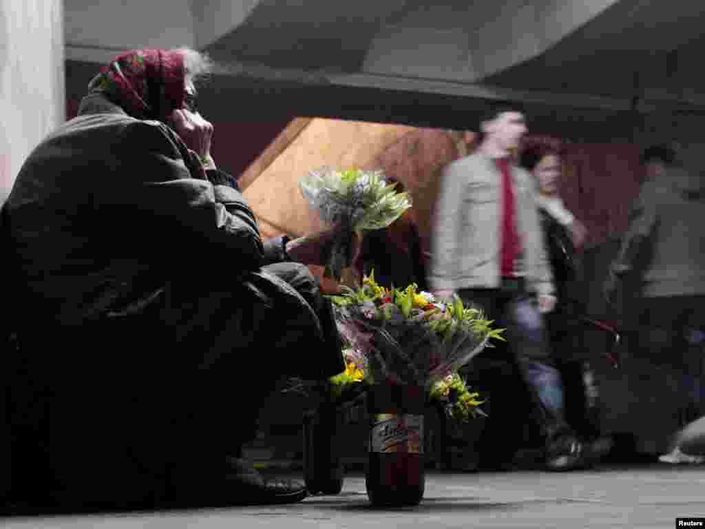 An elderly woman tries to sell flowers at an underground passageway in central Minsk. (Photo by Vasily Fedosenko for Reuters)