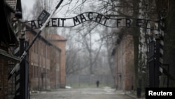 Intrarea de la Auschwitz: Deasupra, mesajul „Muncă te face liber”, lozincă nazistă din timpul celui de-al Doilea Război Mondial.