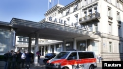 Полицейский автобус увозит арестованных из отеля Baur au Lac в Цюрихе