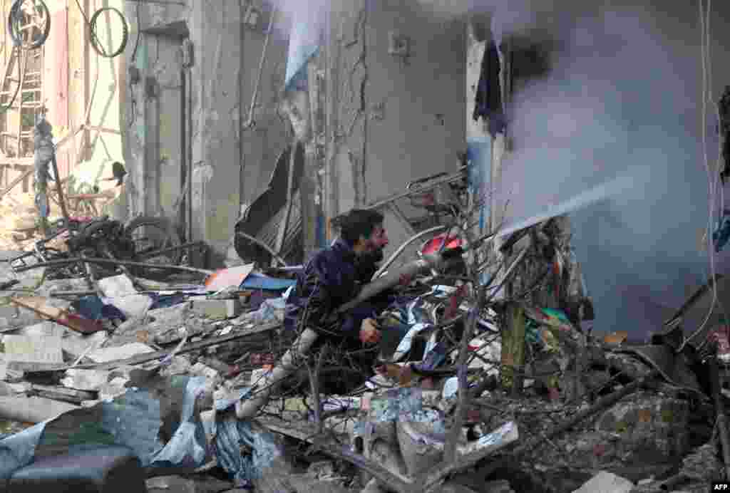 A Syrian man extinguishes a fire in a building following an air strike on the village of Maaret al-Numan, in the country&#39;s northern province of Idlib, on December 4. (AFP/Mohamed al-Bakour)