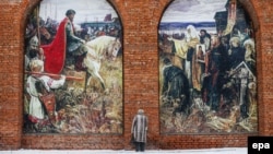 Женщина перед стеной коломенского Кремля с картиной, на которой изображен Дмитрий Донской