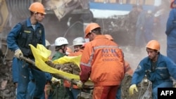 Rescuers remove the body of a victim from the site of September 9, 1999, bombing.