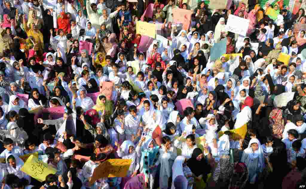 Students of Farooqi Girls&#39; High School wave placards as they stage a protest in Lahore on November 3, demanding the reopening of their school after it was set on fire by an angry mob that alleged the school gave a test that insulted the Prophet Muhammad.