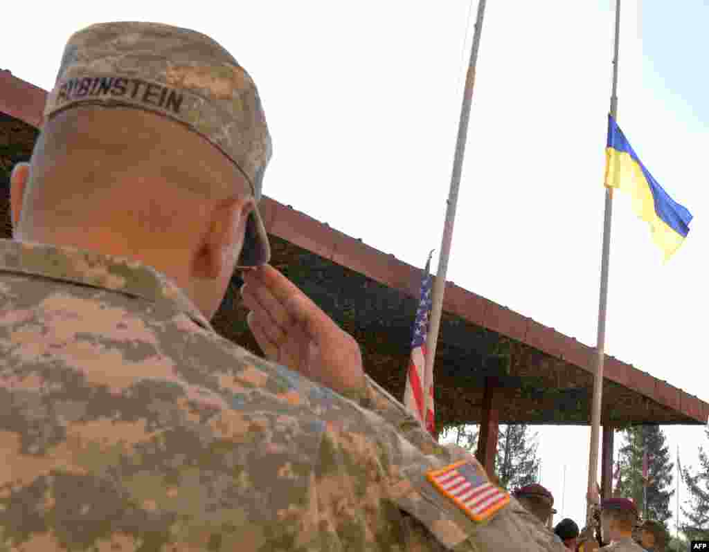 Военнослужащий США отдает честь флагу Украины во время церемонии открытия учений &quot;Быстрый трезубец-2014&quot;. 