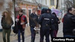 Учасник пікету в Сімферополі розмовляє зі співробітниками поліції, 26 березня 2017 року