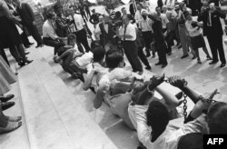 სეგრეგაციის საწინააღმდეგო საპროტესტო აქცია, რომლის დროსაც თეთრკანიანები და შაკვანიანები ერთმანეთზე მიჯაჭვულნი ისხდნენ, 1963 წლის 23 აგვისტოს. 1963 წელს თან ახლდა რასობრივი არეულობები და დემონსტრაციები სამოქალაქო უფლებების დასაცავად.
