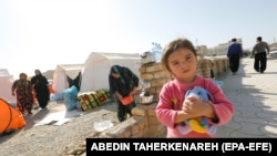 An Iranian child stands near temporary tents for earthquake victims in Kermanshah Province, Iran, 16 November 2017. Thousands still live in temporary tents, without heating.