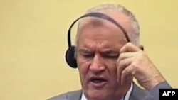 Netherlands -- Former Bosnian Serb army chief Ratko Mladic removes his ear phones shortly before being removed from the courtroom, in The Hague, 04Jul2011