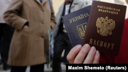 Окупований Крим. Жінка тримає український і російський паспорти біля офісу Федеральної міграційної служби Росії, де вона отримала російський паспорт від окупаційної влади. Сімферополь 7 квітня 2014 року