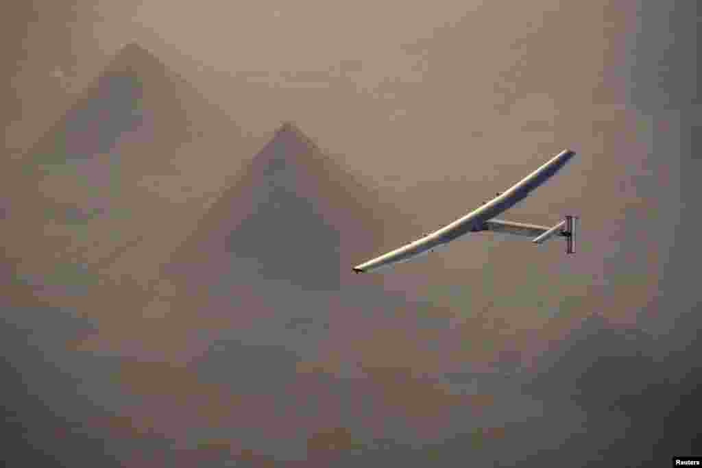 Solar Impulse 2, a solar-powered plane piloted by Swiss pioneer Andre Borschberg, is seen flying over the pyramids of Giza prior to the landing in Cairo on July 13. (Jean Revillard, via Reuters)