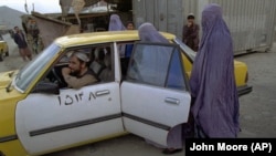 Кабулда паранжа кийген аялдар таксиге отуруп жатат, 8-октябрь 1996-жыл.