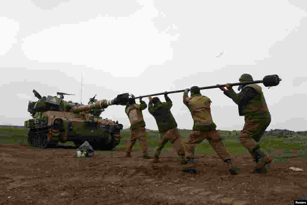 Israeli soldiers clean the barrel of a mobile artillery unit after an exercise in the Golan Heights, near Israel's border with Syria. (Reuters/Baz Ratner)