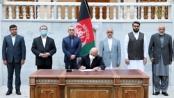Afghan President Ashraf Ghani signs the decree on the release of the final 400 Taliban prisoners in Kabul on August 10.