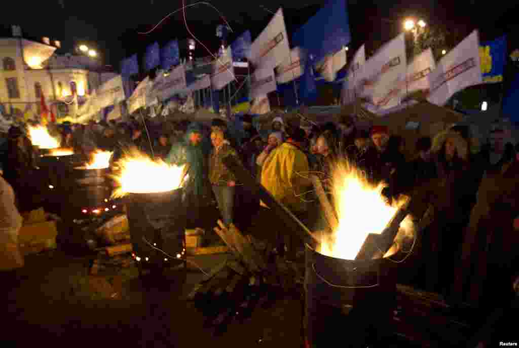 Ukrainian demonstrators warm themselves at fires made in steel drums after a meeting to support EU integration at European Square in Kyiv on November 26. (Reuters/Vasily Fedosenko)