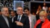 Carlos Tavares (C), chairperson of the managing board of French carmaker PSA Peugeot Citroen, talks flanked by Iranian Industry Minister Mohammad Reza Nematzadeh (L) and Citroen carmaker CEO Linda Jackson during his visit to the PSA Peugeot Citroen stands