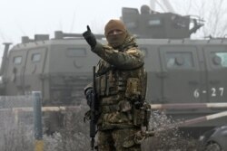 A Ukrainian soldier stands guard near the Mayorsk checkpoint prior to the prisoner exchange on December 29.