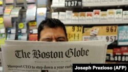 Мужчина с номером американской газеты Boston Globe. Бостон, 15 августа 2018 года.