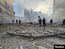 People stand on the rubble of a damaged building after an Israeli strike on Beirut's southern suburbs on March 6.
