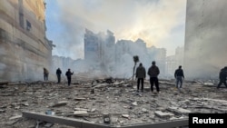 Хора стоят върху развалините на сграда след израелски удар по южните предградия на Бейрут, Ливан, 6 март 2026 г.