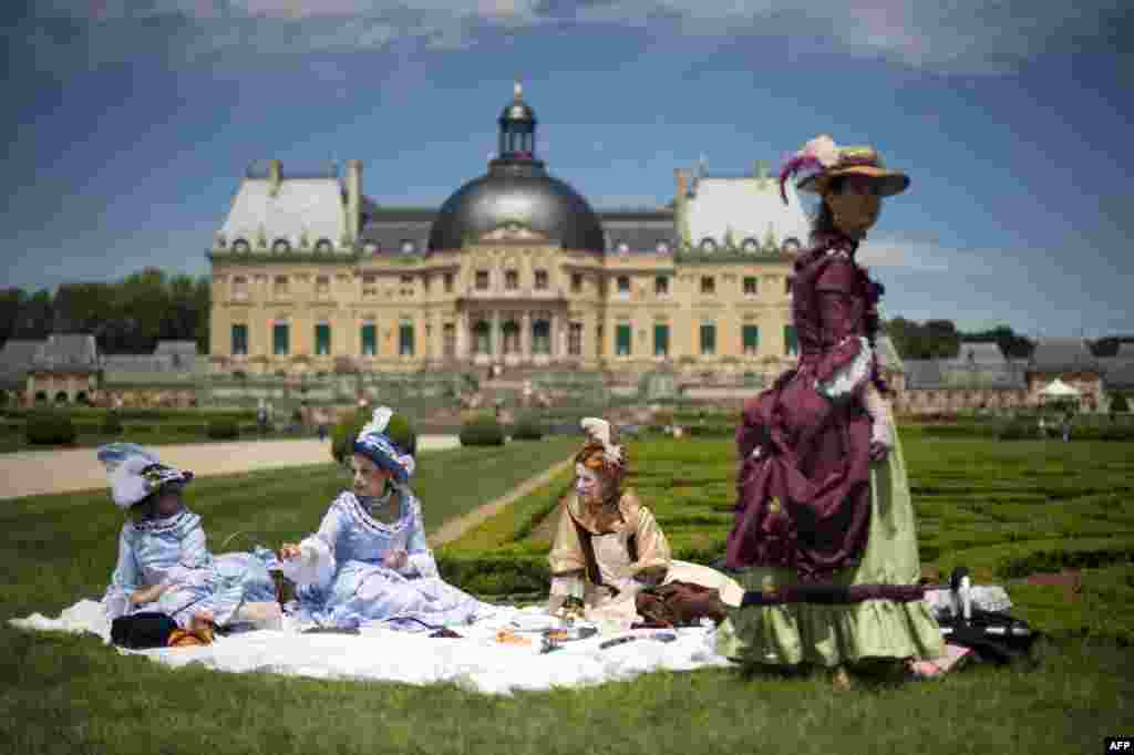 People have a picnic at Vaux-Le-Vicomte castle during the Great Century Day in Maincy, France. The event aims to re-create the atmosphere of the 17th century in the castle and its gardens, which were designed by Andre Le Notre, King Louis XIV&#39;s gardener, who was born 400 years ago. (AFP/Lionel Bonaventure)