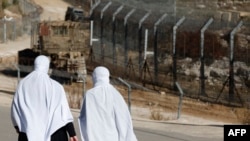 Două femei din etnia druzilor lângă gardul care separă forțele israeliene de cele siriene pe Înălțimile Golan. Zona este și mai „volatilă”, cum spun experții, de când cu războiul civil din Siria și cu incursiunile israeliene în țara vecină.