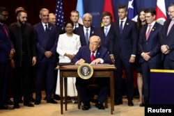 Президент США Дональд Трамп в присутствии лидеров ряда стран Латинской Америки и членов своей администрации подписывает документ "Обязательство по противодействию преступной деятельности картелей" в ходе саммита "Щит Америк" в Майами. 7 марта 2026 года