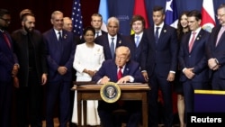 Президент США Дональд Трамп подписывает документ по противодействию деятельности картелей во время саммита "Щит Америк" в Майами, США, 7 марта 2026 года