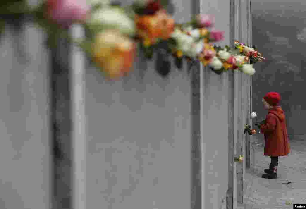 Девочка принесла розы к мемориалу Берлинской стены на Бернаур штрассе (Bernauer Strasse) в честь 25-ой годовщины ее падения. 9 ноября. (Fabrizio Bensch, Reuters).
