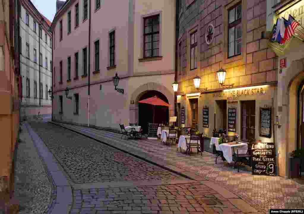 An empty restaurant dining area in Prague&#39;s Old Town at dusk.&nbsp;