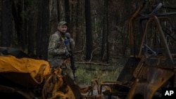 A Ukrainian serviceman walks along a road while searching for dead bodies of his comrades killed in the recently recaptured town of Lyman on October 3. 