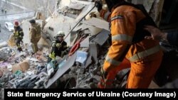 ქალაქ სუმიში რუსული დრონის დარტყმით ნაწილობრივ დანგრეულ სახლში მაშველები 30 იანვარს, დილითაც მუშაობენ.