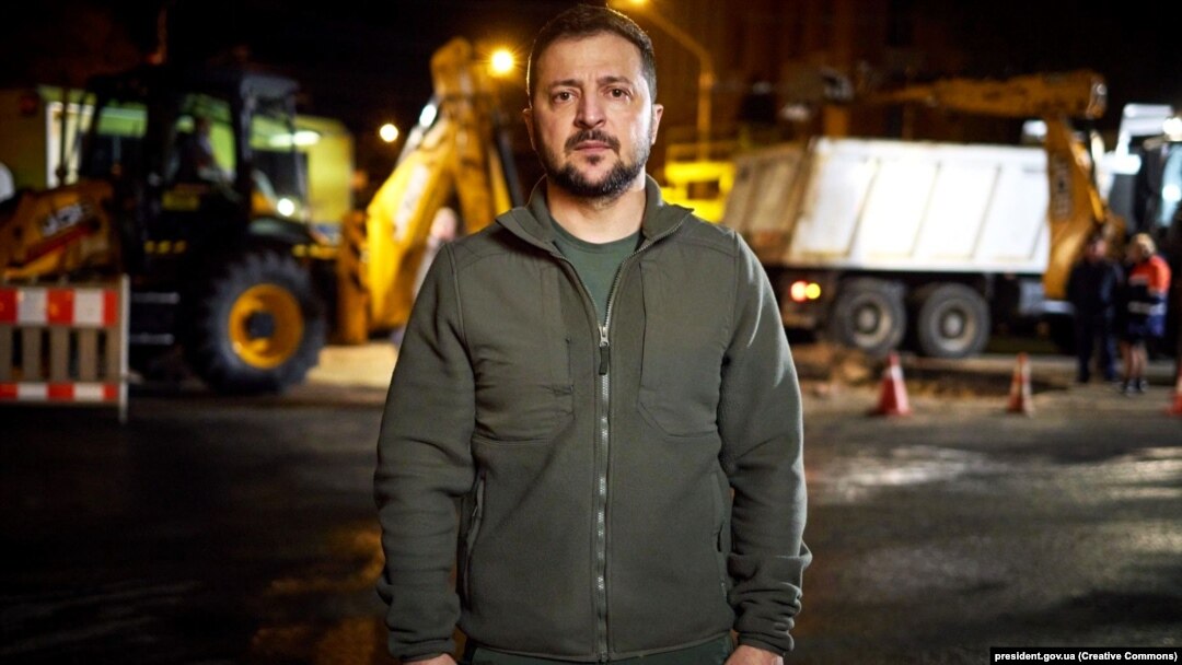 Președintele Ucrainei, Volodimir Zelenski, și-a transmis mesajul de luni seară din stradă. În spatele lui, echipele de intervenție reparau rețeaua electrică avariată în atacurile cu rachetă lansate dimineață de Rusia.