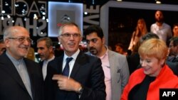 Carlos Tavares (C), chairperson of the managing board of French carmaker PSA Peugeot Citroen, talks flanked by Iranian Industry Minister Mohammad Reza Nematzadeh (L) and Citroen carmaker CEO Linda Jackson during his visit to the PSA Peugeot Citroen stands