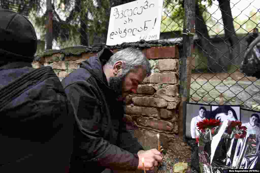 ეზოში, სადაც მკვლელობა მოხდა, ზაზა სარალიძემ მოკლული მოზარდების ფოტოები მიიტანა და სანთლები აანთო.