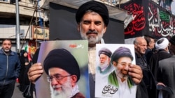 Šiitski muslimanski sveštenik sa slikama novog vrhovnog vođe Irana, ajatolaha Modžtabe Hamneija (desno), i njegovog pokojnog oca, Alija Hamneija, tokom provladinog skupa u centru Teherana 9. marta 2026.