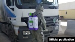 Чек арадан өтүп бараткан жүк ташуучу автоунааны дезинфекциялоо.