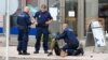 Police officers stand next to a person lying on the sidewalk in the Finnish city of Turku on August 18.