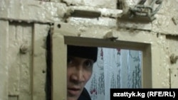 A prisoner speaks through the door of an Osh detention facility during the protests.