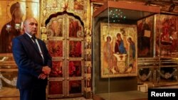 Un agent de securitate, lângă icoana Sfintei Treimi a lui Andrei Rubliov, la Lavra Sfântului Serghie, orașul Serghiev Posad, Rusia, 18 iulie 2022