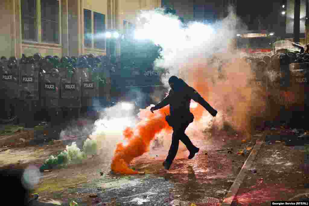 Maskirani policajac šuta dimnu bombu 29. novembra tokom druge noći protesta nakon što je gruzijska vlada objavila da će obustaviti pregovore o pristupanju EU. &nbsp; 