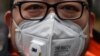 شهروند چینی در شهر شانگهای چین در حالی که بر صورت ماسک زده در ۲۲ ژانویه؛ پژوهشگران و دانشمندان در تلاش هستند تا به رد پای ویروس در مراحل اولیه شیوع آن دست پیدا کنند.